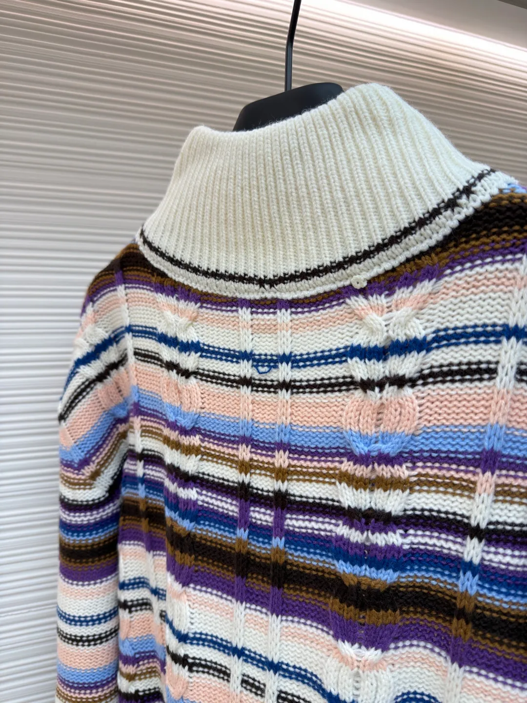 LOUIS VUITTON letter badge color block cable zipper knitted jacket ●Original version: purchased and developed by 21570 ●Item number: 1682322-C15 ●Fabric: wool blended fabric ●Technology: knitting ●Color: pattern ●Version: fitted version ●Weight: about 710 grams ●Size: S-M-L-XL ●Description: This Louis Vuitton color-blocked striped knitted cardigan is made of merino wool and cashmere blended yarn and is woven on a 12-needle coarse-gauge computerized flat knitting machine. The body is interlaced with cable knitting and plain knitting. The stripes are directly knitted with colored yarns instead of post-printing and dyeing. The ratio of colored yarns for each stripe is accurately calculated, making the color transition natural and not easy to fade. The placket is equipped with a customized brass zipper, and the zipper teeth are polished and gold-plated, which is both smooth and durable. The leather label on the left chest is fixed with first-layer calfskin through heat embossing process, and the edges are hand-polished without burrs. The neckline is designed with a high-elastic ribbed stand-up collar, which is not easily deformed after being shaped at high temperatures. The ribbed edges on the cuffs and hem are woven with double-strand yarn, which is more elastic. The shoulders are seamlessly woven with raglan sleeves to reduce the feeling of seams rubbing against the skin. The overall loose fit is combined with three-dimensional tailoring, which not only retains the soft texture of knitting, but also creates a crisp silhouette. Each piece is hand-ironed and quality-checked by brand craftsmen. The overall wiring is straight and delicate, the fabric is comfortable and soft, and the color is consistent without color difference. It can be matched with the same style to create a fashionable look and control various occasions. Customized accessories, complete with three standards, same style for men and women!